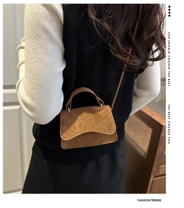 Back view of model wearing a vintage matte brown mini crossbody bag with top handle