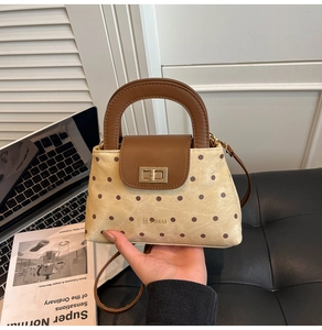 Détail d'un sac à main en toile à pois avec garniture en cuir marron et fermoir doré chic