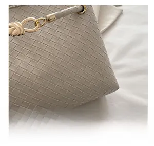 Close-up of cream woven leather texture and elegant metallic ring buckle detail