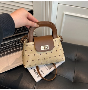 Vue détaillée du sac à main à pois avec poignée en cuir et fermoir doré rotatif