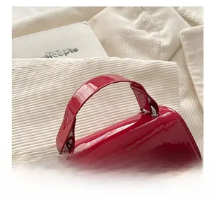 Detailed macro shot of red patent leather mini bag with metallic ring handle attachment