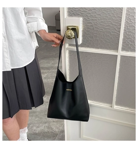 Detailed shot of black minimalist tote bag with golden FASHION print on vintage handle