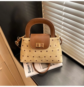 Détail d'un sac en toile rétro à pois avec garniture en cuir brun et fermoir doré