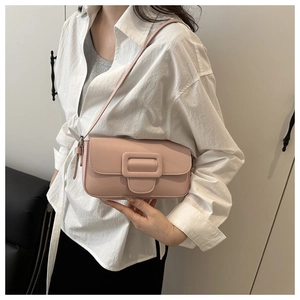 Detailed shot of a pink matte leather flap handbag with oversized matching buckle strap