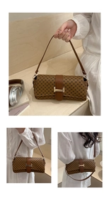 Detail of vintage brown baguette bag with monogram texture and buckle closure