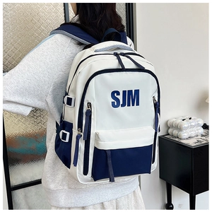Side view of white and blue color-block backpack worn by model in a bright room