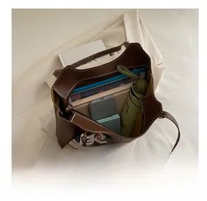 Spacious interior of a brown tote bag with white stitching and floral silk scarf detail