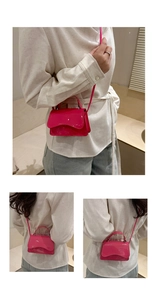 Detail of glossy fuchsia patent leather mini bag with wavy flap and top handle