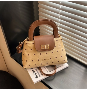 Détail du sac à pois rétro avec rabat en cuir et fermoir rotatif en métal doré