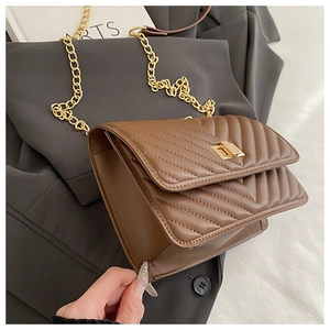 Detail showing the brown V-quilted texture and golden chain strap of the crossbody bag