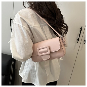 Detailed back view of model wearing a light pink flap shoulder bag with large square buckle