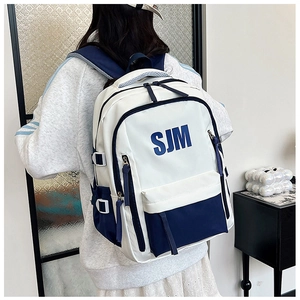 Model wearing a blue and white contrast backpack with side water bottle pocket view