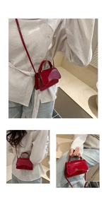 Detail of red patent leather mini bag with wavy flap design and slim shoulder strap