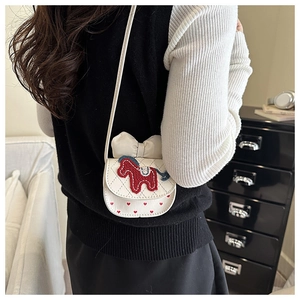 Detail van een witte gewatteerde crossbodytas met een schattige pony-applicatie