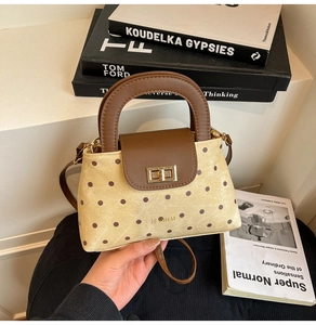 Détail du sac à main vintage à pois avec fermoir doré et poignée en cuir marron