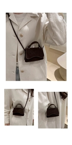 Detail of dark brown suede mini bag with wavy flap design and long crossbody strap