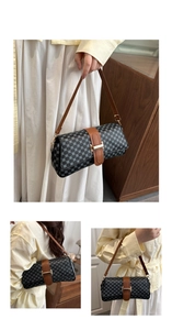 Detail of geometric pattern shoulder bag with brown leather straps and gold buckle
