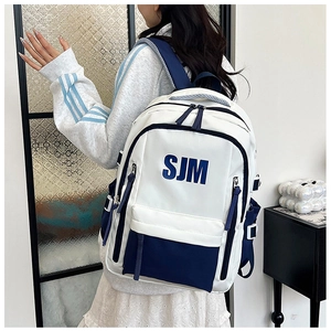 Detail view of large capacity white and blue color-blocking backpack with SJM logo