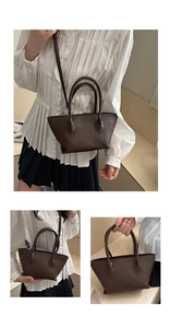 Detail of dark brown pebble leather tote bag featuring round handles and shoulder strap
