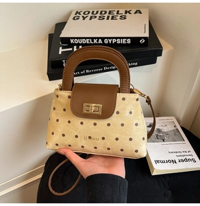 Détail du sac à main rétro à pois en toile avec rabat en cuir marron et fermoir doré chic