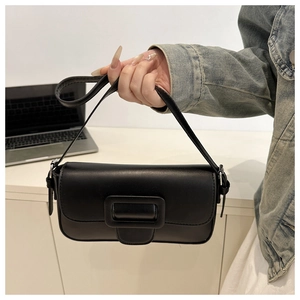 Detail of a black leather underarm bag with a stylish large square buckle decoration
