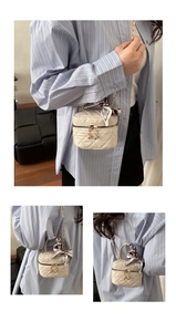 Detailed view of mini quilted bag with gold ball zippers and silk scarf handle
