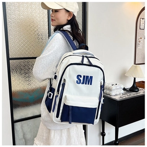 Detail view of large capacity backpack with SJM logo and blue contrast design