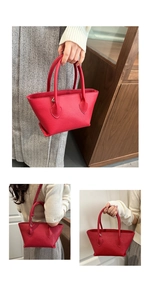 Detail view of red lychee grain leather tote bag showing handles and stitching