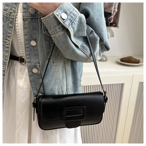 Close-up of sleek black baguette shoulder bag with stylish rectangular buckle detail