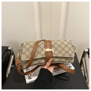 Close-up of vintage floral baguette bag with gold metal buckle and brown leather strap