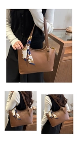 Detailed shot of brown tote bag with contrast stitching and floral scarf on handle