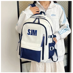 Detail of white and blue backpack with SJM logo, multi-pocket design and padded straps