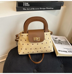 Vue détaillée du sac bandoulière en toile à pois avec finitions cuir et fermoir doré