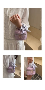 Detail of purple quilted mini bag featuring floral scarf handle and gold ball zippers