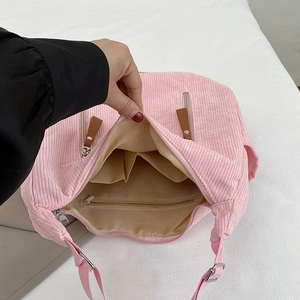 Pink corduroy dumpling bag featuring spacious interior with zipper pocket and dual slots