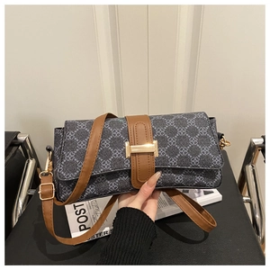 Detail of grey clover print shoulder bag with brown leather straps and gold buckle