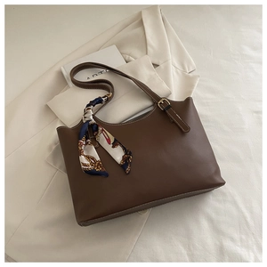 Detail of brown PU tote bag featuring white contrast stitching and decorative silk scarf