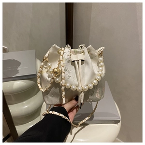 Detailed close-up of floral silk bucket bag with pearl handle and drawstring closure
