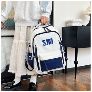Detail of color-block canvas backpack with SJM logo print and adjustable straps