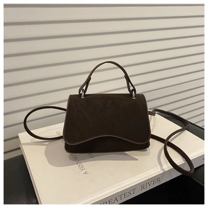 Detail view of dark brown frosted leather small square bag with silver hardware accents