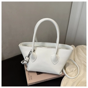 Close-up of white pebble grain faux leather tote bag with cylindrical top handle details