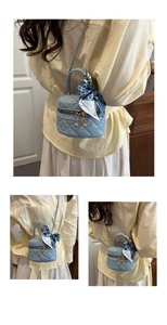 Close-up of a light blue quilted bucket bag with a floral scarf handle and gold hardware