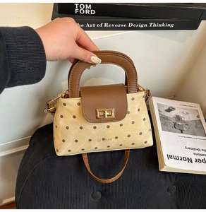 Sac à main à pois avec garniture en cuir marron et fermoir tournant doré