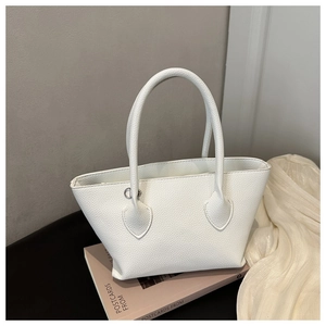 Detail showing the white pebble grain texture and silver D-ring of the leather tote bag