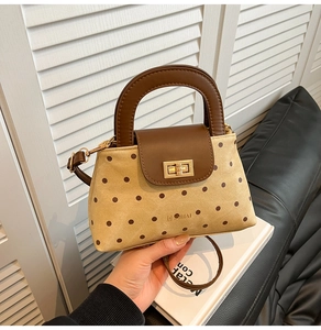 Vue détaillée du sac en toile à pois avec bordure en cuir marron et fermoir doré chic