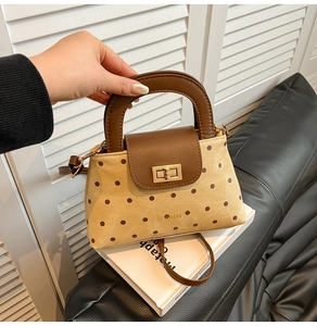 Détail du sac à main vintage à pois avec bandoulière en cuir brun et fermoir doré