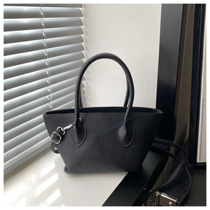 Detail of black lychee grain leather bucket bag with silver hardware and thin shoulder strap