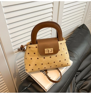 Sac à main en toile à pois avec bordure en cuir marron et boucle dorée sur livres