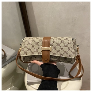 Detail of vintage beige canvas shoulder bag with clover print and brown leather trim