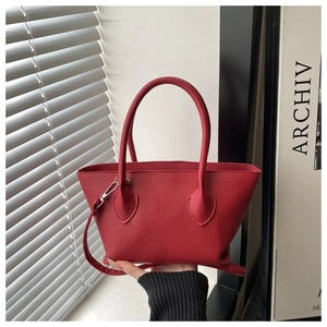 Detail view of mini red bucket bag with lychee grain texture and silver hardware